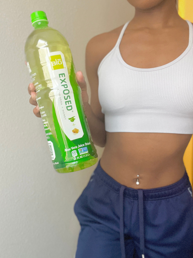 UGC creator in activewear holding a bottle of juice for wellness brand